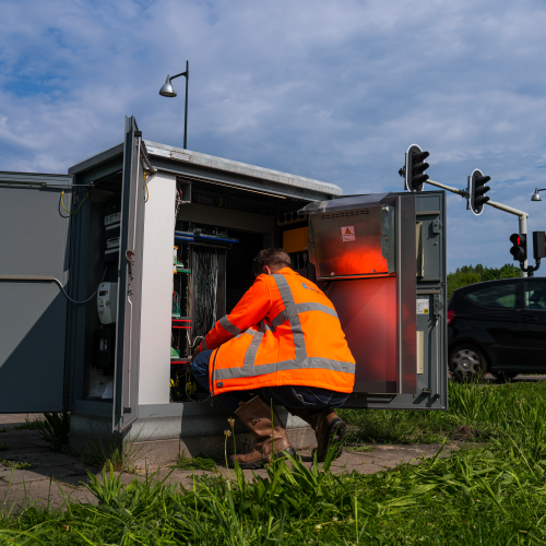 Een medewerker van ViaMobility werkt gehurkt aan een elektriciteitskast