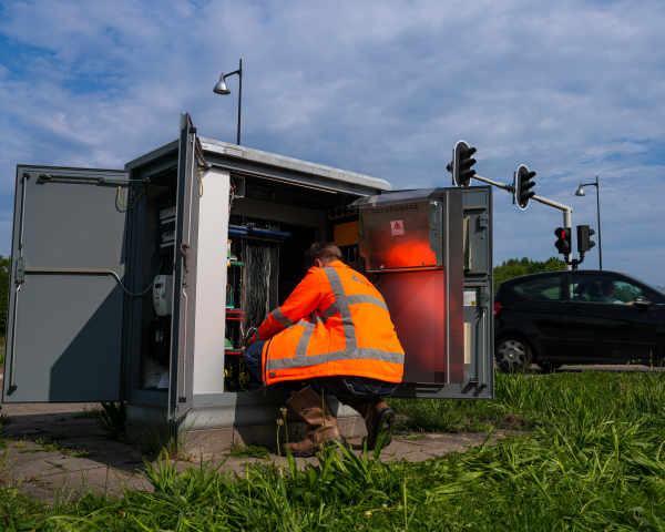 Een medewerker van ViaMobility werkt gehurkt aan een elektriciteitskast
